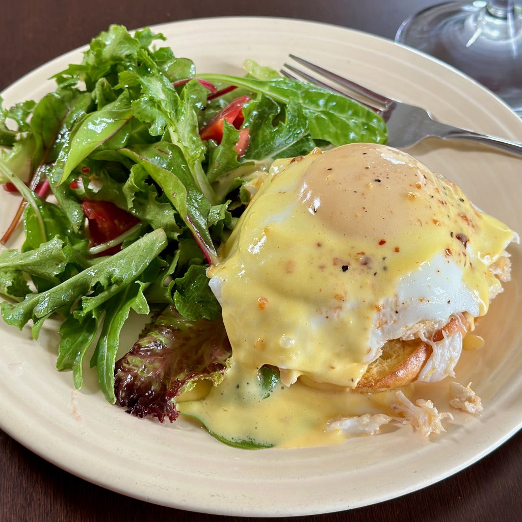 plate of crab eggs benedict and a salad