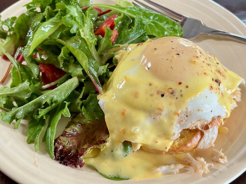 plate of crab eggs benedict and a salad